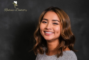 Young woman with wavy brown hair smiling
