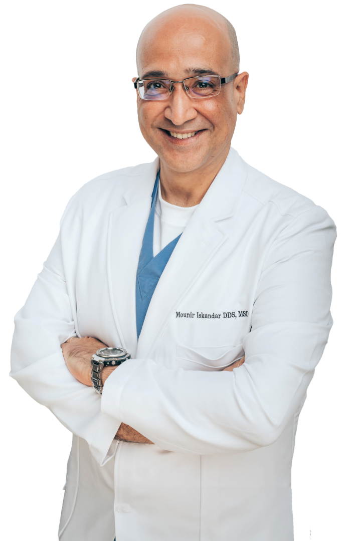 Irving dental implants provider Doctor Mounir Iskandar smiling with his arms crossed