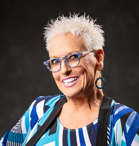 Smiling woman with glasses and spiky blonde hair
