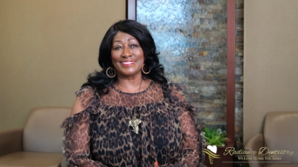 Woman in leopard print blouse talking in dental office