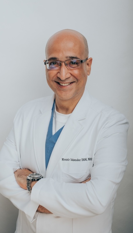 Irving dental implant dentist Doctor Mounir Iskandar smiling with his arms crossed