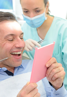 A man smiling after a full mouth reconstruction treatment