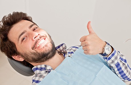 Happy dental patient making thumbs-up gesture