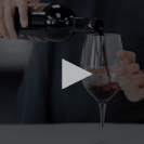 Person pouring red wine into a glass